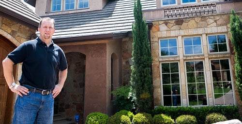 Keith G stands in front of his UFCU financed home