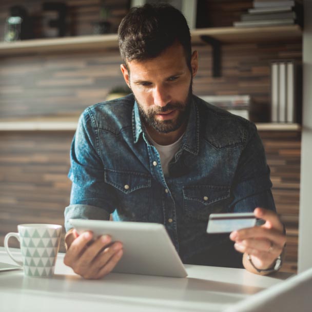 Man looking at a tablet while having some coffee.