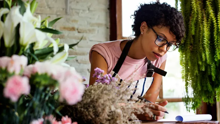 Flower shop owner looking over her ledger.