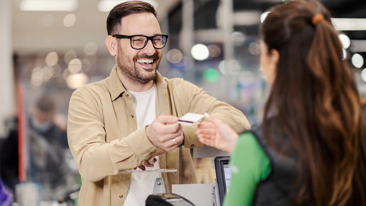 Shopper handing over his credit card to a cashier.