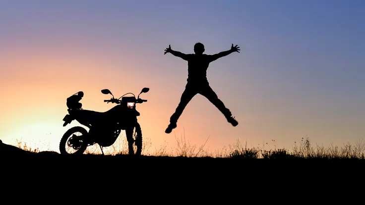 Happy man  jumps for joy while watching the sunset.